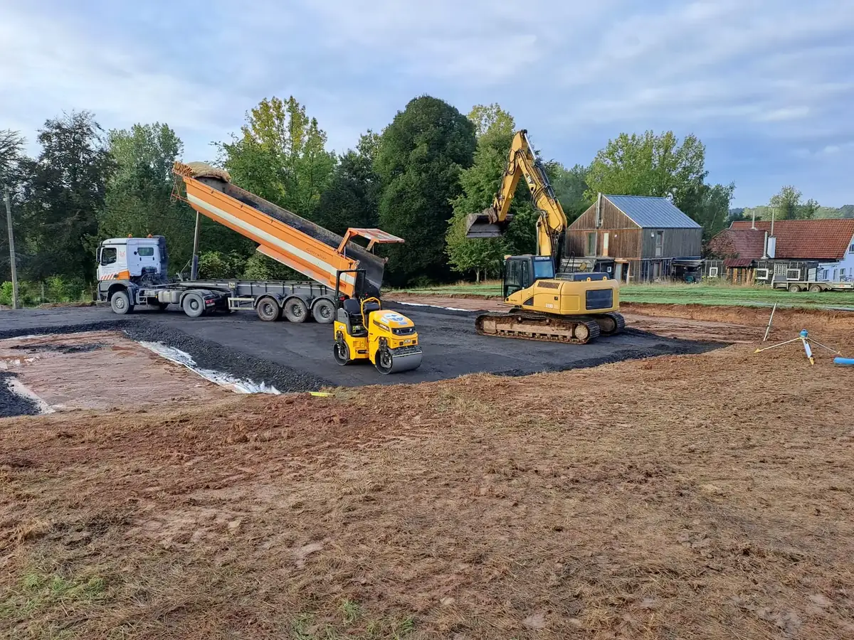 Plateforme empierrée, camion benne et rouleau compresseur